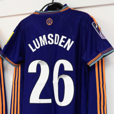 The text reads Lumsden 26 in white with a black trim on the back of a Newcastle United shirt. The font is the new Women's Super League (WSL) and WSL2 font.